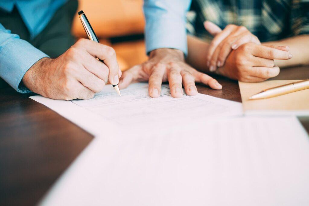 Businesspeople reviewing paperwork, ensuring AML compliance in Australia.