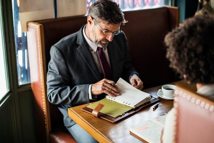 Businessman reviewing documents at meeting, discussing AML/CTF compliance.