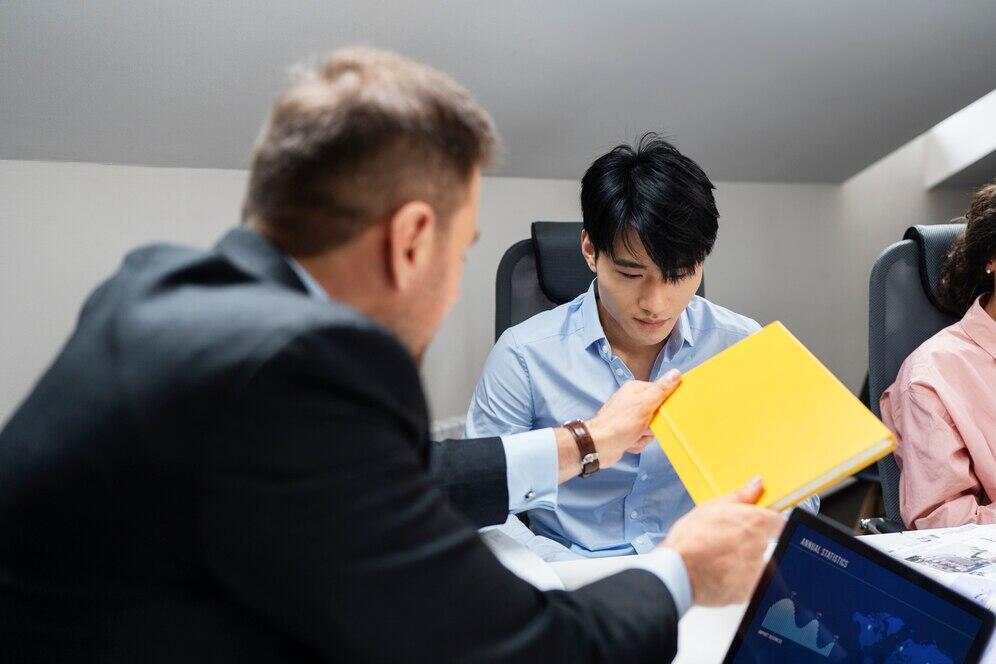 Accountants reviewing documents during a meeting, ensuring AML/CTF compliance.