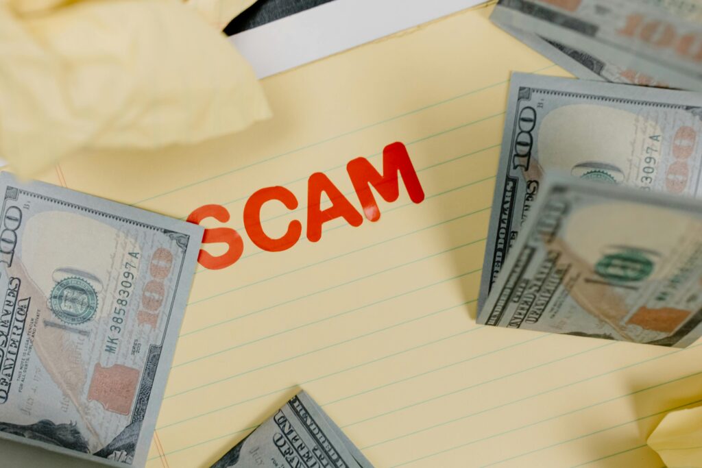 Cash and the word "SCAM" on a notepad; illustrating AML/CTF risks in Australian real estate.